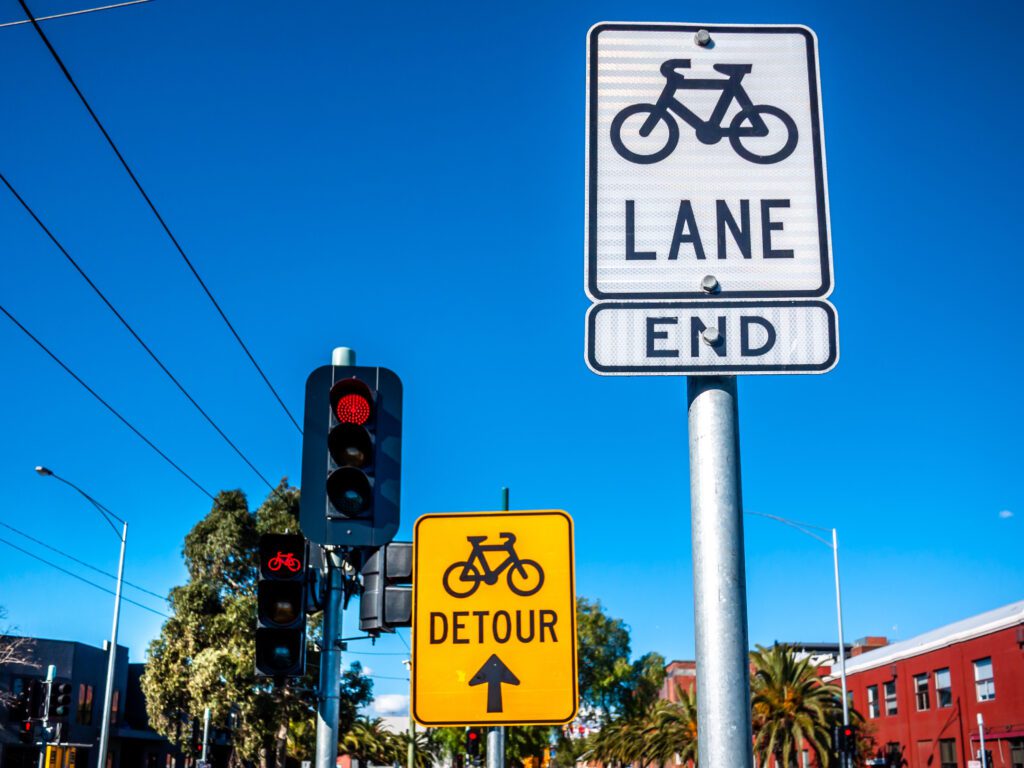Sign of cycleway detour and end of bike lane near traffic light