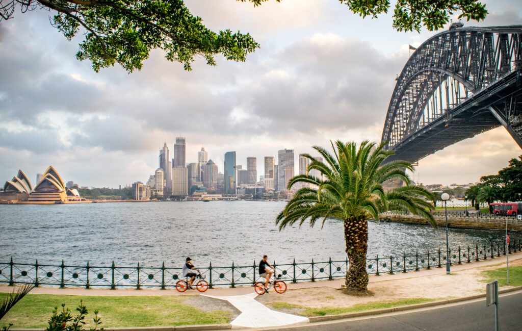 Wide Shot of Tourists Biking along Sydney Harbour, with a view o